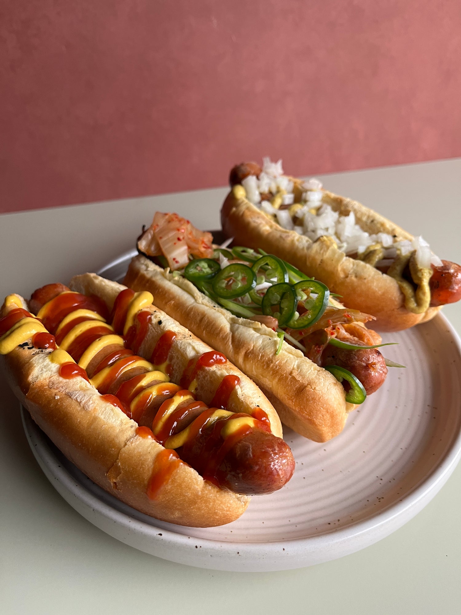 three sausages with various toppings on plate